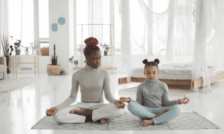 Child and instructor doing yoga together