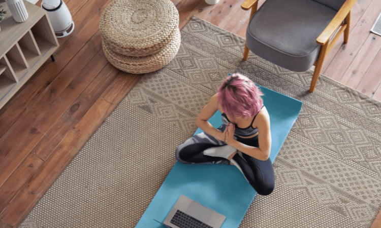 An online yoga teacher guides her students in her online yoga class.