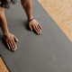 Hands on black yoga mat