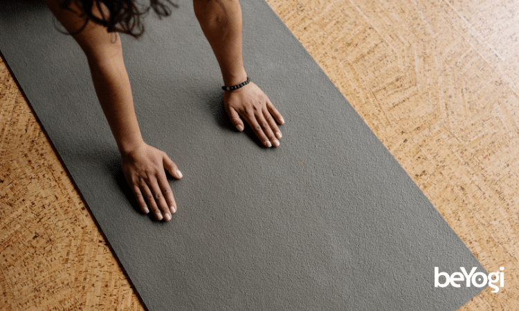 Hands on black yoga mat
