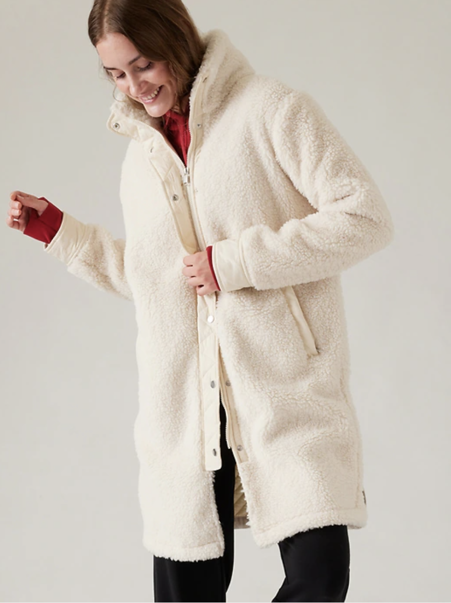 A yogi wears a furry, comfy coat, a mindful yoga gift from a student.