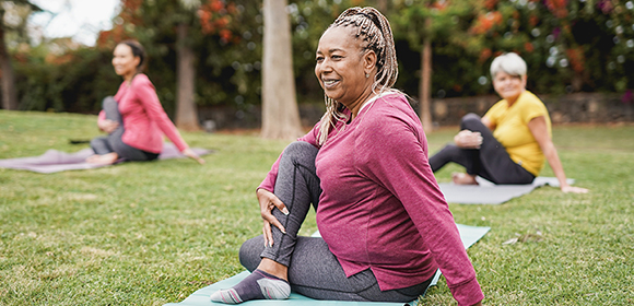 Yoga enthusiasts performing yoga poses outside.