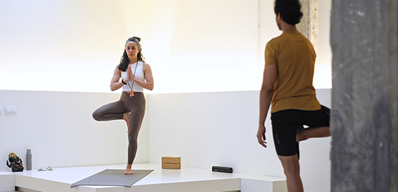 Yoga student learning yoga poses from yoga instructor.