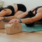 A yoga instructor practices her wrist safety with an ombre yoga block.
