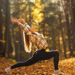 A yoga instructor plays with october yoga class themes in a fall setting.
