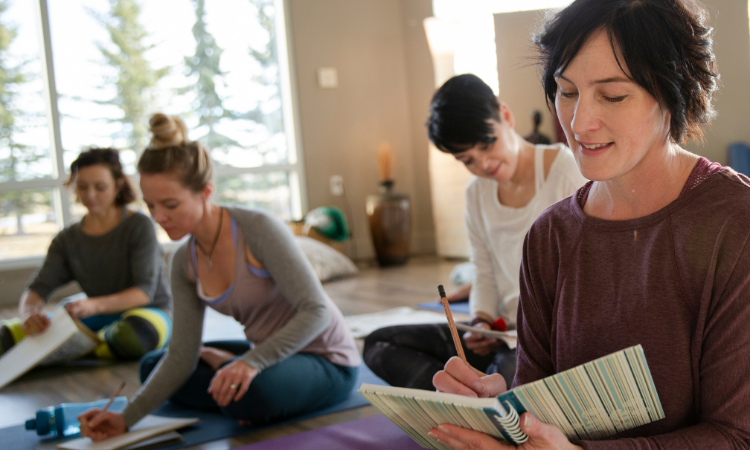 A group of students taking one of the fall yoga class themes journal together.