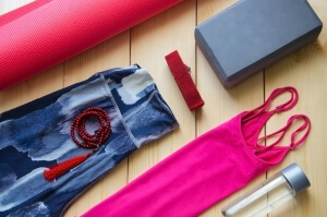 Yoga outfit on wooden background, top view