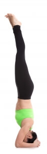 Beautiful sporty girl doing supported headstand yoga asana, salamba sirsasana, inversion, balance pose